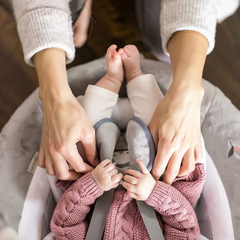 Mom and baby holding hands in baby swing