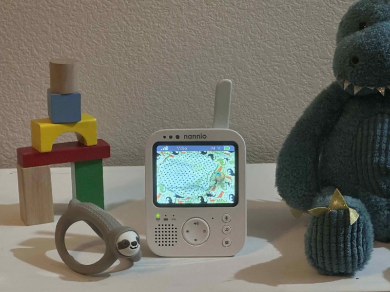 Nannio HERO3 baby monitor with image of baby in crib during the day