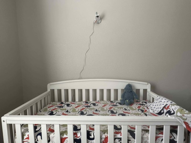 Nannio HERO3 baby monitor installed over crib with cords exposed