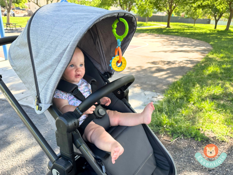 Peg Perego Ypsi stroller with a baby in it and toys hanging from canopy